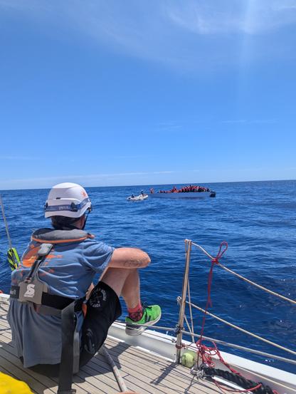 ein Crewmitglied beobachtet, wie sie das Dinghi dem Fluchtboot nähert