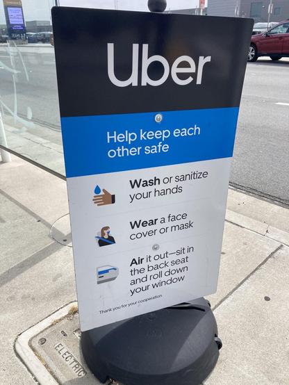 A sign promoting safety measures for Uber users, stating to wash or sanitize hands, wear a face mask, and sit in the back seat with windows down for ventilation. It is designed to encourage cooperation for safety.