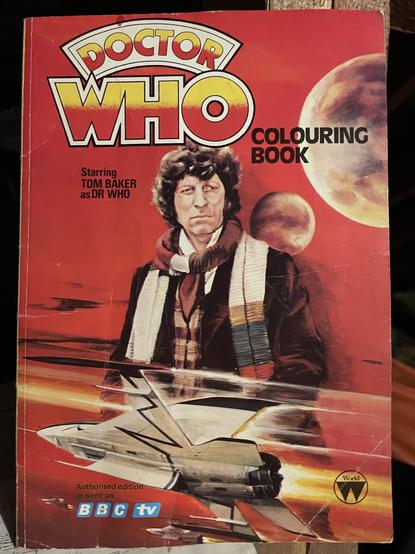 The image depicts a "Doctor Who" coloring book featuring Tom Baker as the Doctor on the cover. The background includes planets and a futuristic spaceship. The primary colors are red and yellow, with the title prominently displayed at the top.