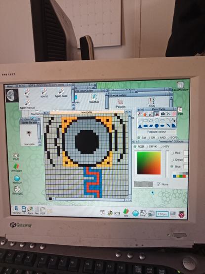 RISC OS desktop screen. Several windows are open. Relevant ones are a large window with a zoomed in icon and a small actual size icon. The icon is a electric speaker pointing towards the viewer. A red square wave is entering the speaker, and it is emitting sound waves. 
What it actually looks like is a big gray flower.