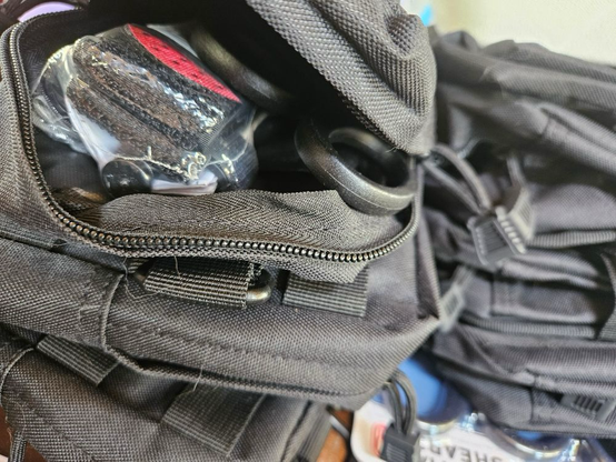 Close up photo of a partial unzipped pack revealing IFAK supplies like a tourniquet kit and scissors