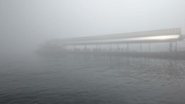 A pier at Takamatsu Port, except that there is heavy fog. I'm a few dozen meters away and it's barely visible. There are some people waiting in line and the ferry to Oshima, but it's not running.
