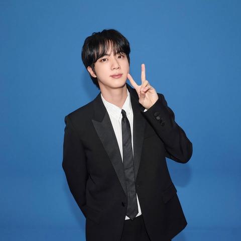 Jin being WWH in a suit, sending a peace sign