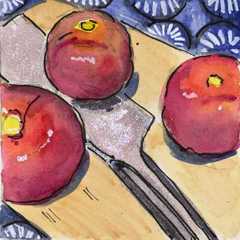 A large knife lying on a cutting board. Sitting near the knife is a trio of tomatoes. The cutting board is sitting on a blue tablecloth with an abstract floral pattern.