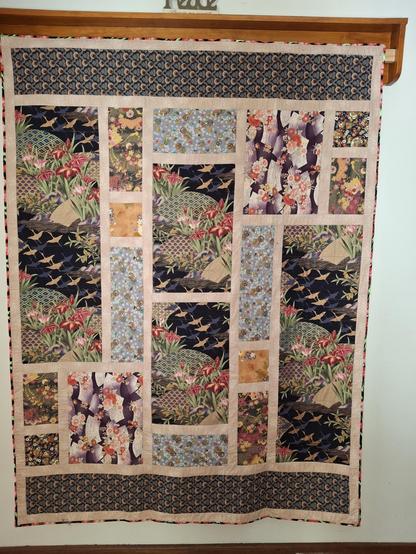 A quilt made with Japanese fabric which features birds, flowers and fans.