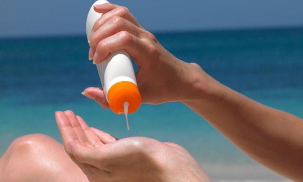Una mujer se aplica crema solar en la playa. (Dougal Waters via Getty Images)