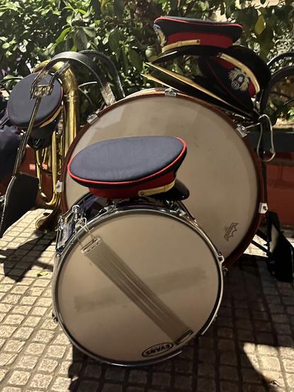 Two drums, a trumpet, marching band uniform hats stacked outside the church of St Dionysios the Areopagite in Athens, waiting for the Good Friday mourning procession