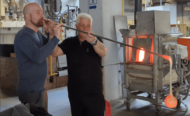 Ich mit dem Glasbläser beim Ausformen einer Durstkugel. Kugelform noch sichtbar.