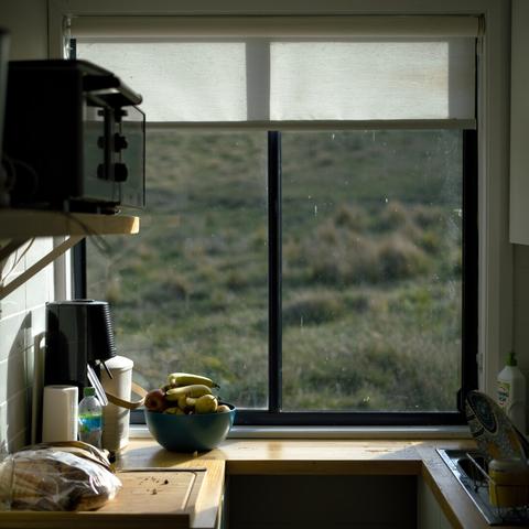 Photo of a kitchen in the late afternoon with a view out of a window onto grassland
