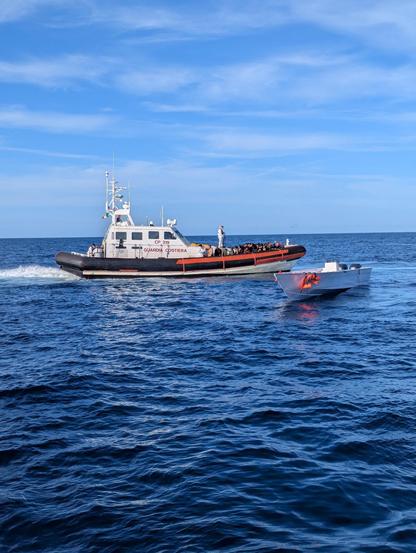 das Rettungsboot der italienischen Küstenwache nimmt alle Menschen an Bord