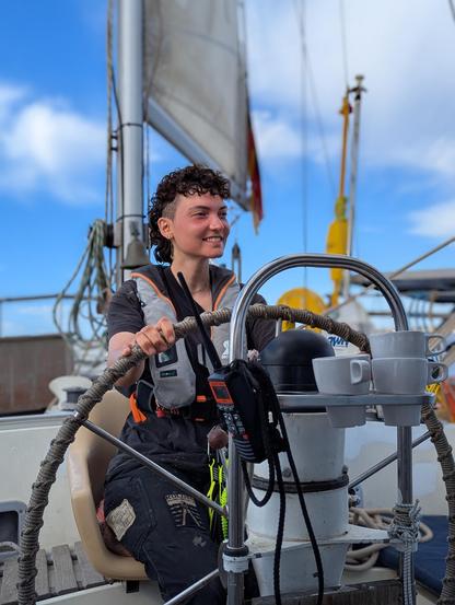 ein Crewmitglied am Steuer der Trotamar III, die wieder Kurs auf Sizilien genommen hat