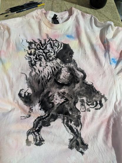 Drawing of bigfoot wearing thigh high platform boots, black fabric paint on light tie dye rainbow shirt (it's gildan deadstock)