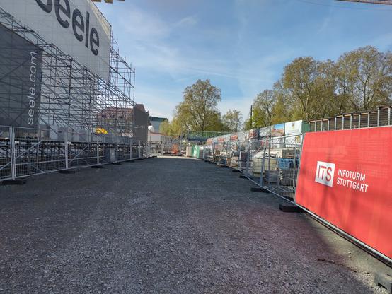 Links die Halle mit der Gitterschale. Zentral im Bild ein Weg auf dem nicht eine Person ist, da alle durch die Halle gehen.