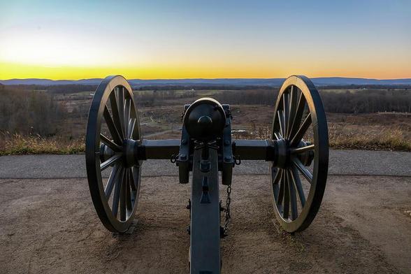 Cannon on Little Round Top at Gettysburg battlefield, seen at sunset, symbolizing the historic events of the Civil War.