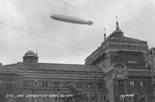 A black and white photo of an airship over Den nationale scene (The National Theatre) in Bergen.