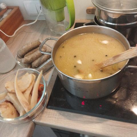 Dwie miski i garnek na indukcji, w jednej misce biała kiełbasa, w drugiej warzywa z gotowania. W garnku jednostka absolutna - żurek