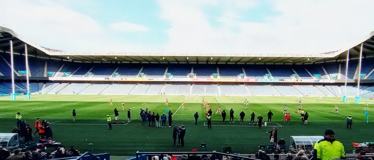 An oversatured Murrayfield stadium with the players lining up against each other for a restart. Accies in blue/white and GHA in red/green