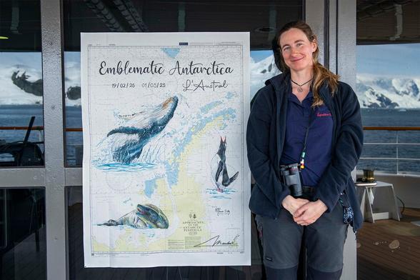 Moi posant à côte de la carte marine que j'ai peinte. Il s'agit d'une carte de la péninsule antarctique avec une baleine, un manchot et un léopard de mer. Dans le reflet de la vite on voit le paysage antarctique où cette photo a été prise.
