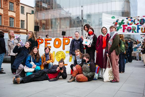 The Fridays for Future Stockholm group members around the big banner "People not profit".