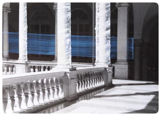 A handprinted, analog picture of the interior of an Italian palace, with a mysterious, handpainted, iridescent stripe passing behind handpainted white columns.