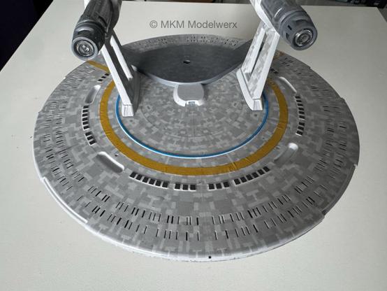 Closeup of the saucer section showing the blue and yellow stripes and dark grey escape pods.