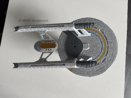 Looking down at the underside of the model with the blue and yellow striping and dark grey escape pods