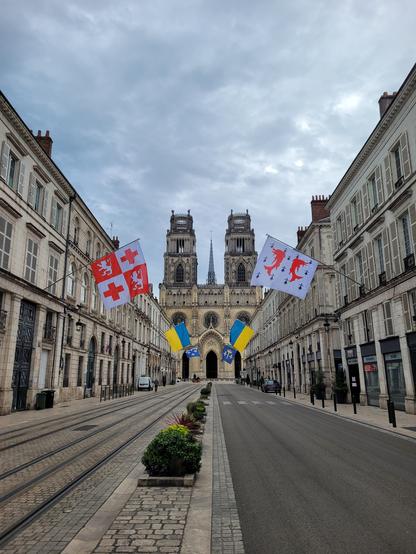 Cathédrale d'Orléans et drapeaux de chaque côté de la rue, ruelle vide