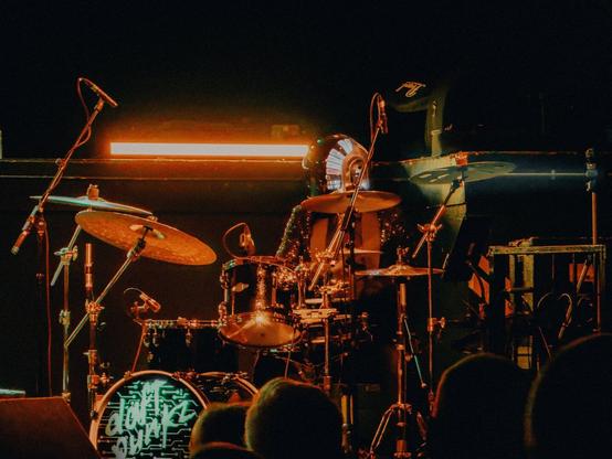 A close up of the drummer, wearing a Daft Punk-style helmet.

The drumkit has the band’s logo on it which says “Daft Punkz”.