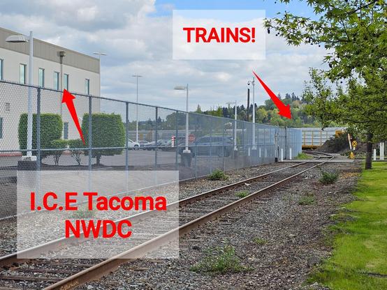 Photo of Northwest Detention Center in Tacoma (ICE concentration camp) with arrow pointing to boxcars of train directly behind the facility