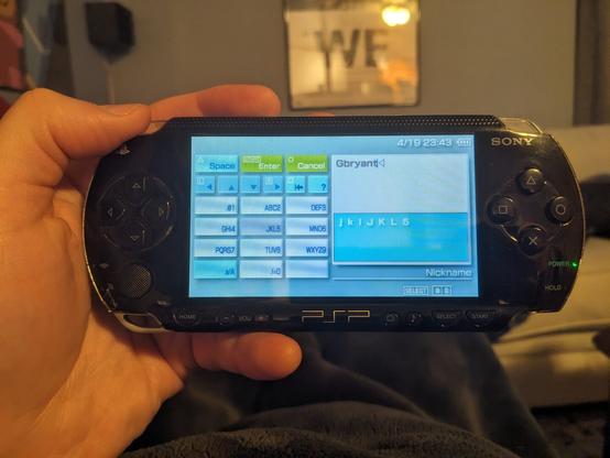 The PSP 1000 with a T9 virtual keyboard on screen.