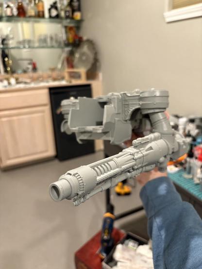 The reaver Titan body, with the shoulder attached via a rod and bolt and the cannon suspended via the magents. A small wet bar is in the background.