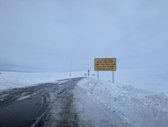 Snowy road with an orange sign