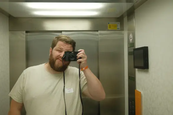 Man with a beard taking a selfie in an elevator mirror