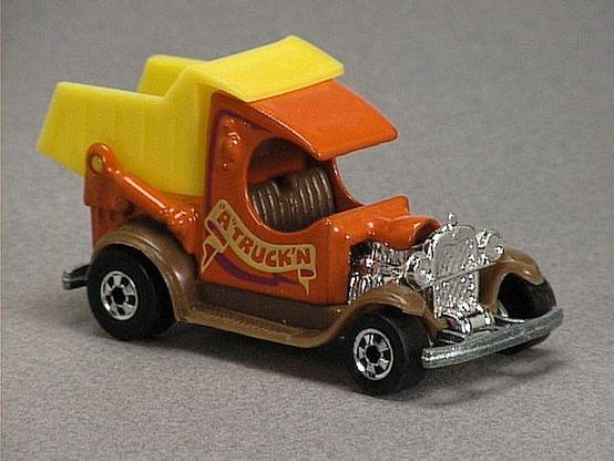 Released in 1984, Orange Dumpin' A of 1984 Hot Wheels with Black Wall wheels. Notes: Based on the Model A Ford dump truck with movable yellow dumper on back and exposed chrome colored engine in front and light brown plastic fenders. Tampo: Purple and red with 'A Truck 'N' and 'Dump' on sides. Packaging: 1984 Blister. Metal Body, Metal Base. Made in Mexico. Scarcity: 8/10