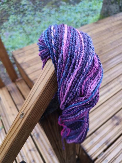 Sateisella terassilla villalankaa, jonka väri vaihtelee pinkistä violetin eri sävyihin.
