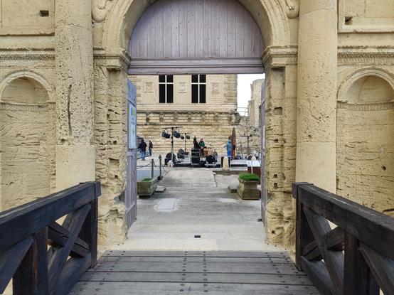 Vu sur la cour du château de la Tour-d'Aigues, où se prépare le spectacle du soir. On voit la porte ouverte, le donjon renaissance et quelques projecteurs sur la scène