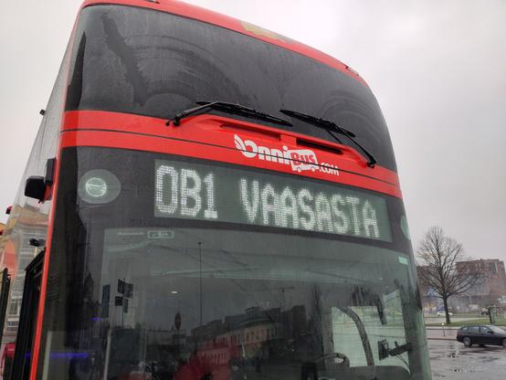 Sateisen Turun linja-autoasemalla punainen OnniBus-linja-auto, jonka tuulilasin valotaulussa teksti OB1 VAASASTA.