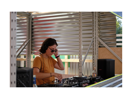 young person djing in fancy dj booth in outside festival situation