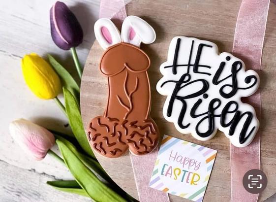 Chocolate penis with bunny ears and a "He is risen" cookie. Flowers and a "happy Easter" note round out the image.