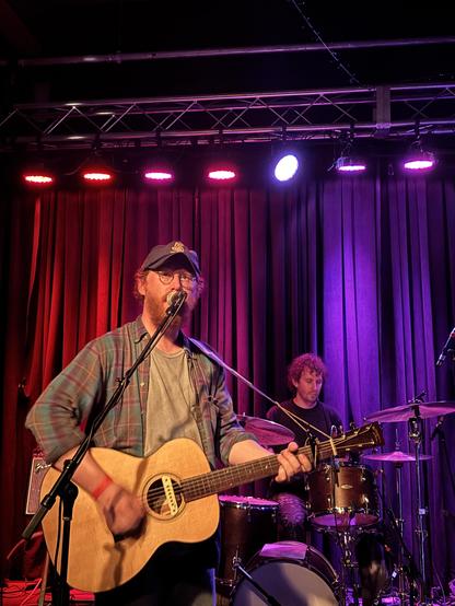 Aaron, lead singer onstage with guitar.