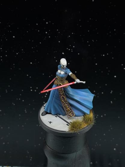 Asajj Ventress miniature from Star Wars shatterpoint with a blue cloak, golden and brown decoration, pale skin and a pair of red lightsabers