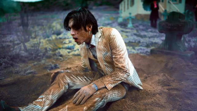Here he is getting up from a graveyard. His suit is covered in dirt.