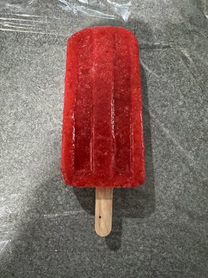 Strawberry popsicle (paleta) on a kitchen counter.