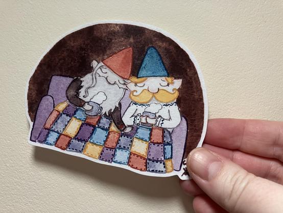 Sticker of a watercolour painting of two gnome husbands sitting on their cozy sofa under a patchwork blanket, drinking steaming cups of cocoa.
