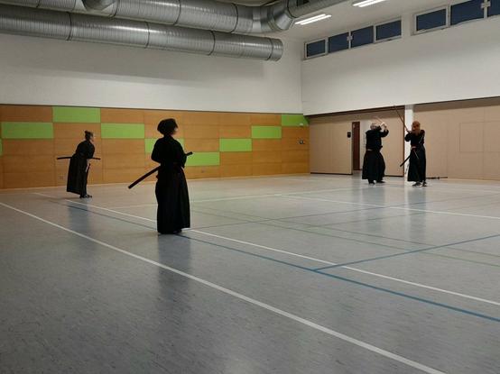 4 people in black gi training