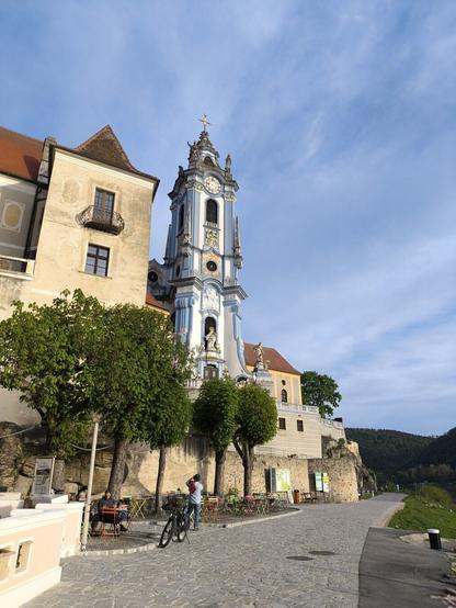 Ein blau weißer Kirchturm und andere Gebäude daneben.