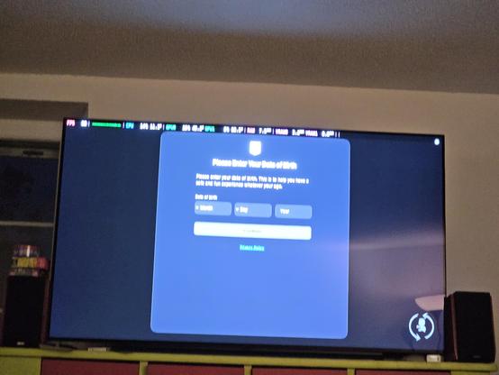 A tv with SteamOS trying to start sackboy the game. But instead we can see an overlay in the game asking for the age of the user.

The overlay is from the epic game store.