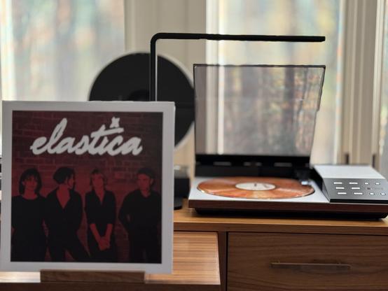Elastica - Elastica LP.

Red tinted black and white photo, white border, white title “elastica”, four band members against a brick wall.

The clear LP with red/orange splatter is playing on a vintage, restored Bang & Olufsen Beogram 8002 linear-tracking turntable to the right.