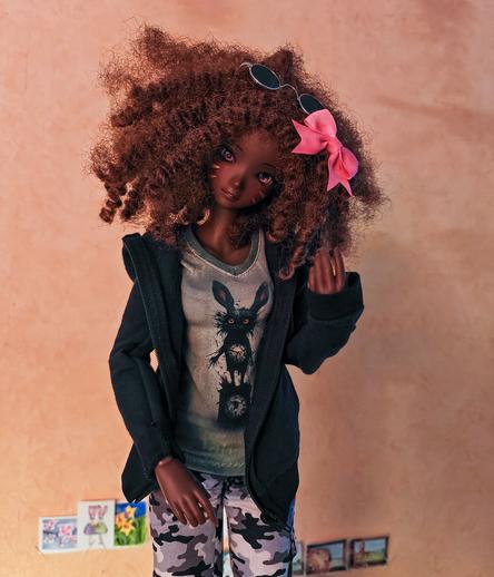 Black Smart Doll with brown, curly hait,  wearing a hoodie and a goth bunny T-shirt