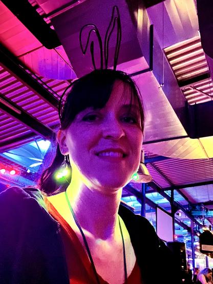 Selfie: ich lecke in die Kamera, meine Ohrringe bestehen aus leuchtenden LEDs. Hinter mir zieht man bunte Lichter und Lichterketten und die bunt erleuchtete Wellblech Decke über meinem Kopf